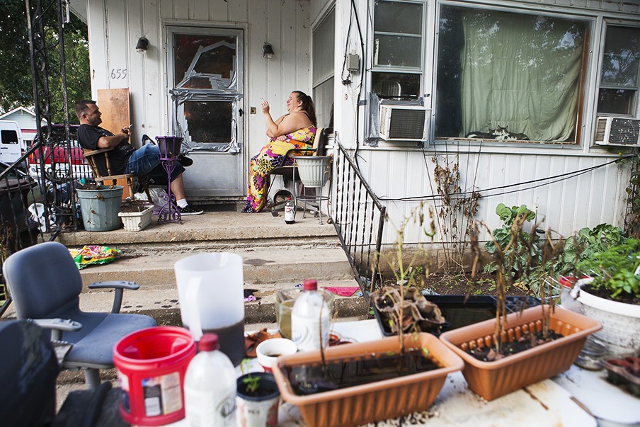 Mike en Desiree rokend op de veranda voor hun huis. Waarschijnlijk moeten ze binnenkort uit het huis vertrekken omdat ze de rekeningen niet meer kunnen betalen. Foto: Barbara Doux/Hollandse Hoogte
