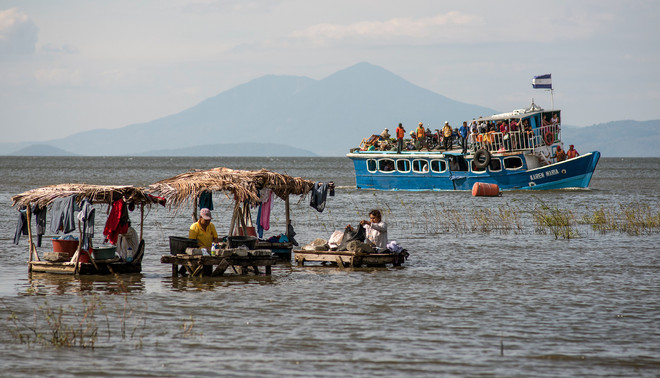 Op de voorgrond wassen lokale bewoners hun kleren in het Nicaraguameer, op de achtergrond vertrekt een passagiersboot richting Ometepe. Foto: Teake Zuidema
