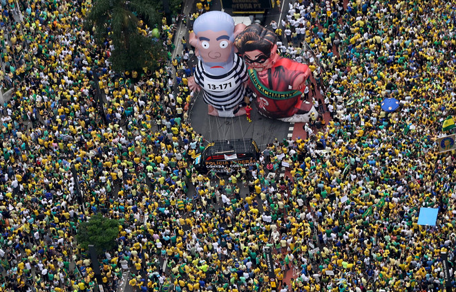 Gigantische inflatables genaamd 'Pixuleco' domineren het straatbeeld tijdens de protesten tegen de benoeming van oud-president Luiz Inacio Lula da Silva door de huidige president Dilma Rousseff (13 maart 2016). Beeld: ANP