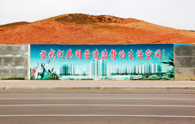 Een billboard laat de toekomst van de wijk Kangbashi in de stad Ordos mei 2011, China. Ordos ligt in de autonome regio Binnen-Mongolië en laat zich vanuit het Mongools vertalen naar "paleizen" en de stad is gevuld met vers gebouwde flats in pas ontsprongen woonwijken, bedoeld voor arbeiders van de dichtbij gelegen koolmijn. "Laat ons samen een schone en stille woonomgeving bouwen!" is de leus. David Gray / Reuters