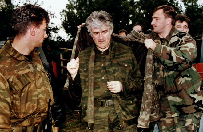 Radovan Karadzic wordt door zijn bodyguards in zijn jas geholpen na een televisieoptreden in Pale op 6 september, 1995. Foto: Reuters