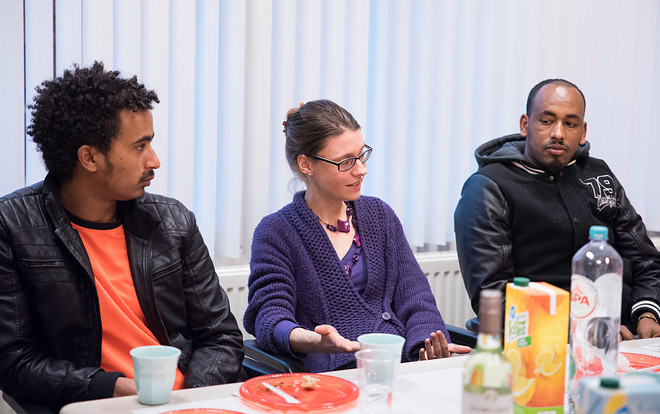 Tijdens de kerstborrel van de inburgeringsklas waar Colette van Nunen klassenassistent is. In het midden lerares Marieke de Peuter, links en rechts van haar cursisten. Foto: Romi Tweebeeke (voor De Correspondent)