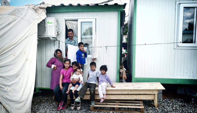 11 mei 2017: Een Afghaanse familie met zes kinderen voor hun eigen container in een vluchtelingenkamp nabij Athene. Foto: Louisa Gouliamaki / AFP