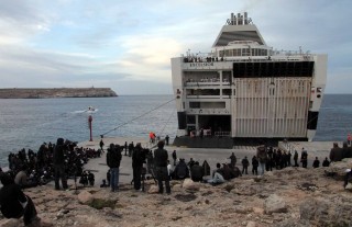 Maart 2011: Noord-Afrikaandse migranten wachten op het Italiaanse eiland Lampedusa tot ze aan boord kunnen van een schip dat hen naar het vasteland van Italië zal brengen. Foto: Michele Naccari/ANP