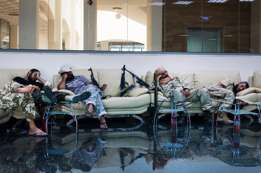 Rebellen rusten uit in het kantoorgebouw van het staatsoliebedrijf in Tripoli, nadat ze het tijdens gevechten hebben ingenomen, op 25 augustus 2011. Foto: Hollandse Hoogte