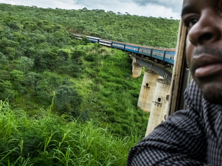 Een passagier kijkt naar buiten terwijl de trein over een brug rijdt. In totaal zijn er ongeveer driehonderd bruggen op de route. Foto: Sean van der Steen