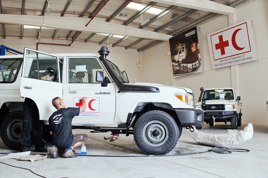 Auto’s worden klaargemaakt voor het veld, in de garage van de IFRC in Dubai. Foto: Pieter van den Boogert