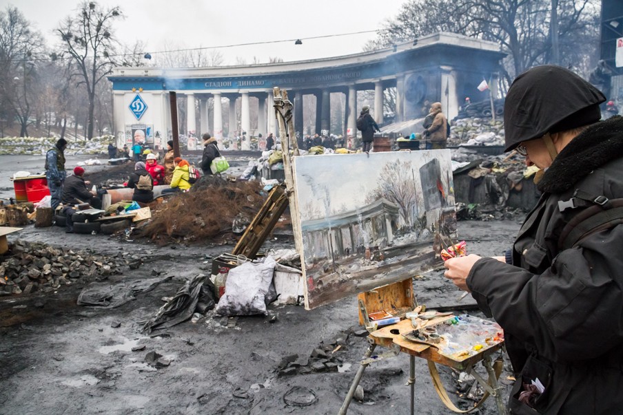18 februari 2014: De Oekraïense kunstenaar Sergey Pushchenko schildert de barricades van het Maidanplein. Foto: Guy Corbishley/Hollandse Hoogte