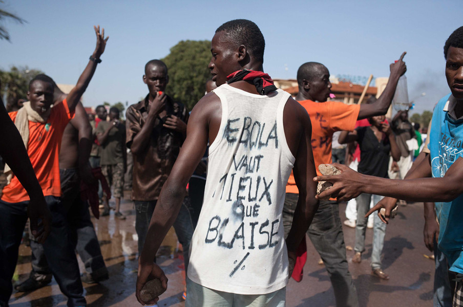 Een demonstrant draagt een hemd waar een vergelijking op staat van Blaise Compaoré met Ebola. Foto: Sophie Garcia/Hollandse Hoogte
