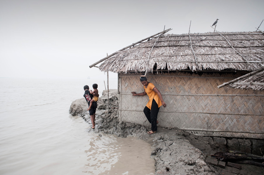 De land onder dit huis aan de kust van Bangladesh wordt bijna door de zee ingenomen. Foto: Alessandro Grassani / Hollandse Hoogte
