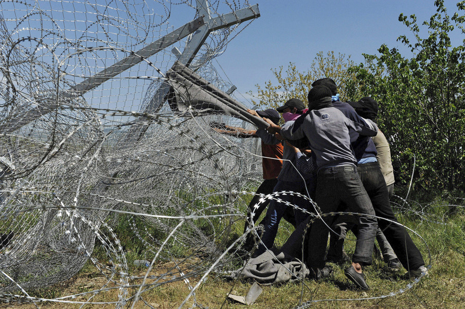 16 april 2016: Vluchtelingen proberen het hek te verwoesten op de grens tussen Griekenland en Macedonië. Foto’s: Alexander Avramidis / Reuters