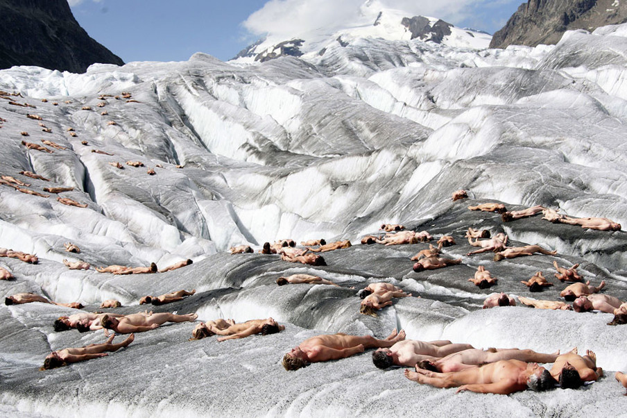 Naakte vrijwilligers poseren voor de Amerikaanse fotograaf Spencer Tunick op de ijskoude Zwitserse gletsjer Aletsch. Dit is de making-of  van een Greenpeace-campagne over de opwarming van de aarde. Foto: Fabrice Coffrini / AFP