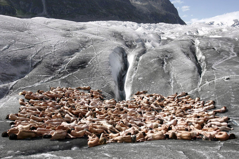 Naakte vrijwilligers poseren voor de Amerikaanse fotograaf Spencer Tunick op de ijskoude Zwitserse gletsjer Aletsch. Dit is de making-of  van een Greenpeace-campagne over de opwarming van de aarde. Foto: Fabrice Coffrini / AFP