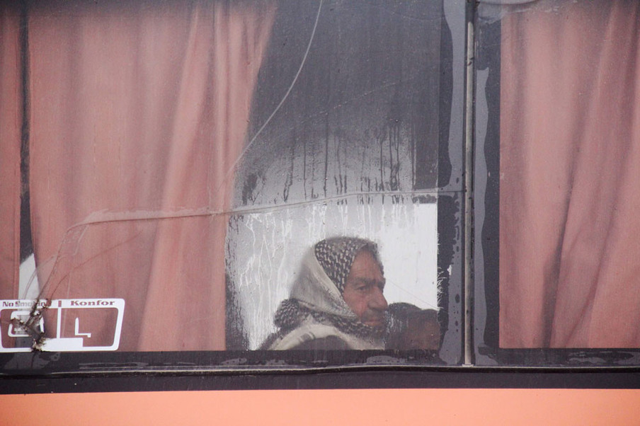 Syriërs zitten aan boord van een bus die vanuit Fuaa en Kafraya mensen naar Rashidin evacueert op 14 april, 2017. Foto: Omar Haj Kadour / AFP / ANP