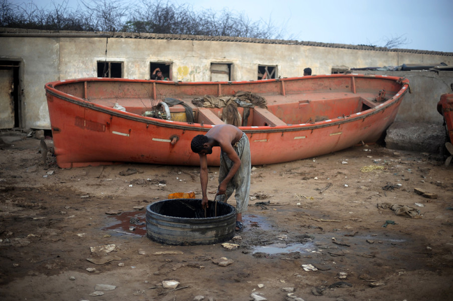  Een werknemer haalt water uit een put om zichzelf te wassen na een dag hard werken op een sloopwerf, Pakistan, 2012. Foto: Roberto Schmidt / AFP