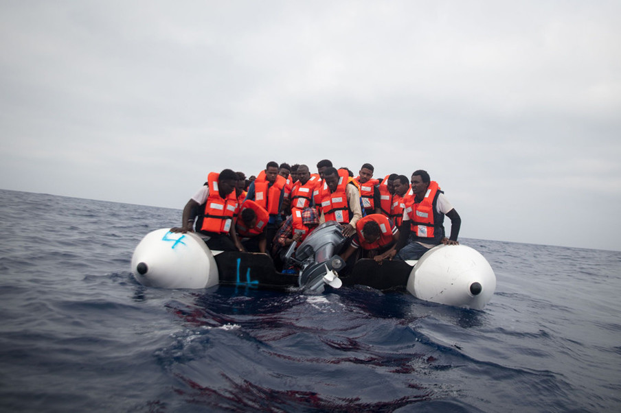 Migranten proberen de kapotte motor van hun rubberboot te laten zinken, om zo veilig af te kunnen meren aan het Sea-Watch reddingsschip, 5 juni 2018. Foto: Erik Marquardt