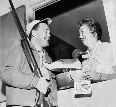 Een onsuccesvolle jager geeft zijn vrouw lokaas en een kookboek. Foto: Underwood Archives / Getty Images