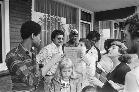 Bewoners Coenhotelflat (Amsterdam) protesteren tegen de slechte huisvesting van Surinamers. Krantenkop: ‘Coenhotel: ghetto voor Surinamers’. Foto: Rob Bogaerts / Nationaal Archief